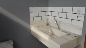 ein weißes Waschbecken mit einem Wasserhahn in einem Badezimmer in der Unterkunft Guest House em Tiradentes MG in Tiradentes + 11 Fotos