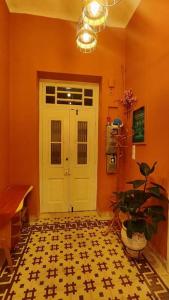 a hallway with a white door and a potted plant at Yellow and blue relax house in Piraeus