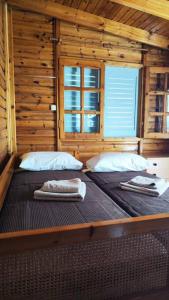 1 dormitorio con 2 camas en una cabaña de madera en Yellow and blue relax house en Piraeus