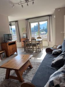 a living room with a couch and a table at Appartement Le Rochettois - VALGELON LA ROCHETTE - 25 mn station de ski Collet d'Allevard in La Rochette