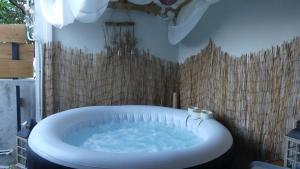 a bath tub in a bathroom with a wooden wall at Le Farin la pluie by LONBRAZ VOLKAN in Saint-Philippe