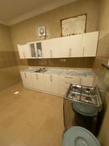 a small kitchen with a stove and white cabinets at قصر المنار in Jeddah