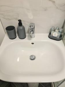 a bathroom sink with a soap dispenser on it at Homestay by BIC Oates 8 in Dewsbury