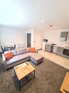 a living room with a couch and a table at Homestay by BIC Oates 8 in Dewsbury