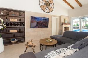 a living room with a couch and a clock on the wall at Luxury Villa Lunika near Brela, Baska Voda, Makarska in Lovreć
