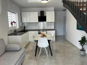 a kitchen and living room with a table and chairs at Holiday Home Bajlo in Zadar
