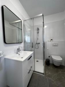 a white bathroom with a sink and a shower at Holiday Home Bajlo in Zadar