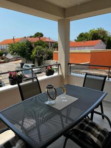a table with a glass of wine on a balcony at Holiday Home Bajlo in Zadar