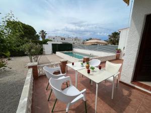 une terrasse avec une table, des chaises et une piscine dans l'établissement Casa Gonia, à Riumar