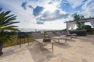 a patio with chairs and a view of the ocean at Luxury Villa Lunika near Brela, Baska Voda, Makarska in Lovreć