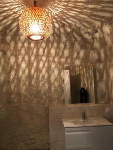 a bathroom with a sink and a mirror on a wall at Nuit insolite dans une troglodyte ! in Nazelles