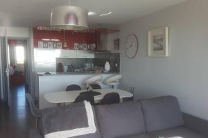 un soggiorno con un divano e un tavolo di FORT MAHON superbe appartement face mer a Fort-Mahon-Plage