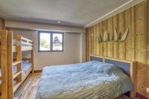 a bedroom with a bed and bunk beds and a window at Carline in Morillon