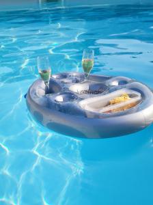 a swimming pool with a raft with glasses of wine at Le clos des crins in Pavilly
