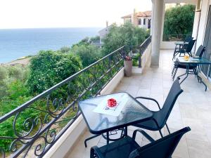 a balcony with a table and chairs and the ocean at Guesthouse HHL - Liman ll in Ulcinj