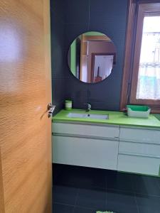 un baño con lavabo y espejo en Casa privada centrica, en Villanueva de Arosa 13 fotos más