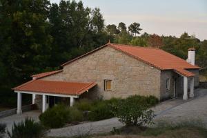 ein kleines Steingebäude mit orangefarbenem Dach in der Unterkunft Casa Lagar da Moira in Vila Franca da Serra