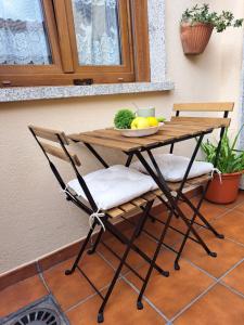 una mesa y sillas con un bol de fruta. en Casa privada centrica, en Villanueva de Arosa
