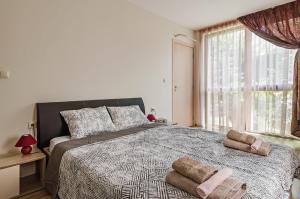 a bedroom with a large bed with two towels on it at Garden Palace in Varna City