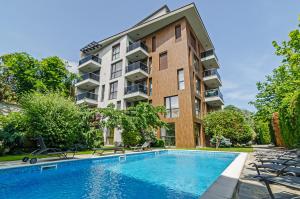 an apartment building with a swimming pool and chairs at Garden Palace in Varna City