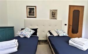 two twin beds in a room with two pictures on the wall at Casa Agnese Verona appartamento parcheggio in struttura in San Martino Buon Albergo