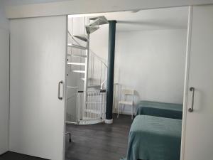 een kamer met een bed en een wenteltrap bij IMPLUVIUM Conil-Terraza Privada-Parking- mayores de 25 años in Conil de la Frontera