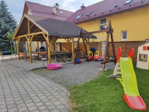 einen Spielplatz mit einem Holzpavillon und einem Spielbereich in der Unterkunft Relax Jasna in Liptovský Mikuláš