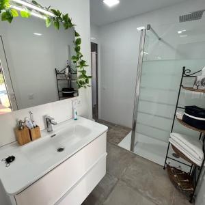 a white bathroom with a sink and a shower at Villa Rios in Xàtiva