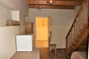 a hallway with a white refrigerator and a yellow door at Taoskari Hotel in Vardzia