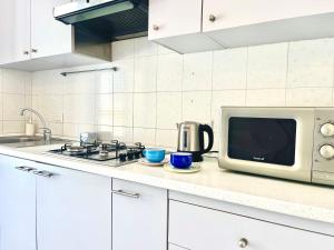 a kitchen counter with a microwave and a stove at Casa Loren in the heart of Sorrento in Sorrento