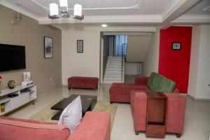 Elle comprend un salon doté d'un mobilier rouge et d'un mur rouge. dans l'établissement Royal Suites Apartments, à Lusaka