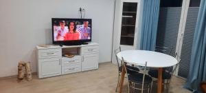 a living room with a table and a television on a cabinet at Apartament Świerkowa 11 in Augustów