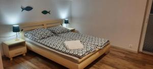 a bedroom with a bed and two night stands with a lamp at Apartament Świerkowa 11 in Augustów