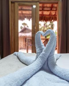 a pair of towels forming a heart on a bed at Pousada Vila Tapera in Barra Grande