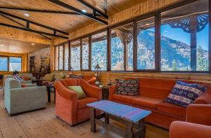 a living room with orange furniture and a mountain view at SVANETI in Lentekhi