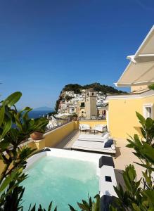a swimming pool on the balcony of a house at Palazzo M Capri in Capri