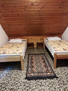 マギャーヘフカランドにあるMecsek Virágai Lakの木製天井のドミトリールームのベッド2台分です。