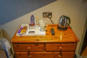 a table with a coffee maker on top of a dresser at The Bird In Hand Inn, Witney in Witney