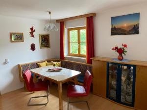 a dining room with a table and red chairs at Ferienwohnung Lehen in Sankt Veit im Pongau