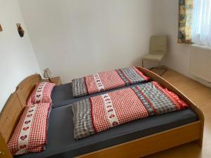 a bed with three pillows on top of it at Ferienwohnung Lehen in Sankt Veit im Pongau