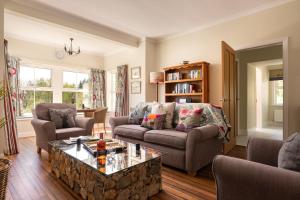 a living room with a couch and a coffee table at Orroland Holiday Cottages in Dundrennan