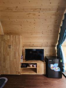 a living room with a television and a small cabinet at Mio Hotel in Hải Dương