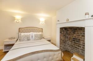 a bedroom with a bed with a brick fireplace at The Garden Square - Unique luxury apartment in historic garden square - for up to 4 people in York