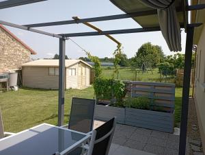 pergola na patio ze stołem i krzesłami w obiekcie LE JOLICY w mieście Nexon