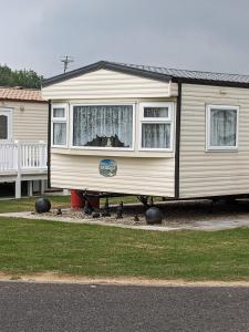 a tiny house sitting on the side of a house at Millfields 6 berth caravan MAX 4 ADULTS Bob family's only and lead person must be over 30 in Ingoldmells