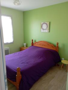 1 dormitorio con 1 cama grande con sábanas moradas en LE JOLICY, en Nexon