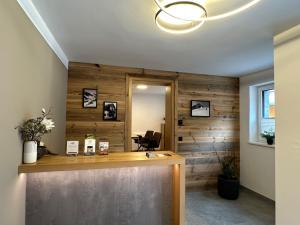 an office with a wooden accent wall with a reception desk at Appartement Christina in Saalbach Hinterglemm