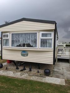a tiny house is sitting in a yard at Millfields 6 berth caravan MAX 4 ADULTS Bob family's only and lead person must be over 30 in Ingoldmells
