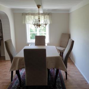 a dining room with a table with chairs and a window at Gårdshuset Håverstad in Iveland