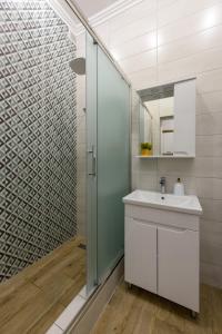 a bathroom with a sink and a glass shower at Апартаменти на Кобилянській by Willox in Chernivtsi +13 photos